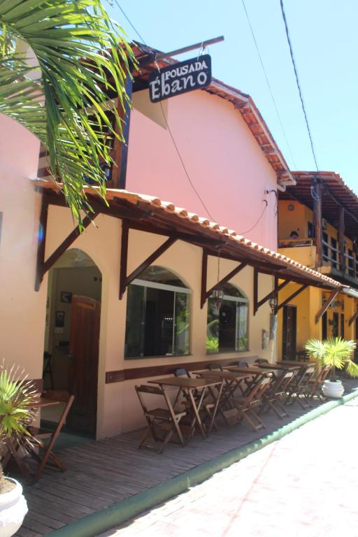 a restaurant with tables and chairs in front of a building at Ébano Pousada in Morro de São Paulo