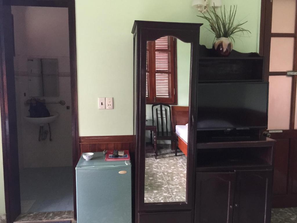 sala de estar con espejo y TV en Khách sạn nam đông, en Quang Tri