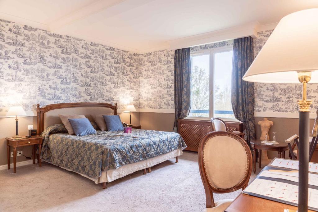 a bedroom with a bed and a window at Le Manoir De La Poterie & Spa in Cricquebœuf