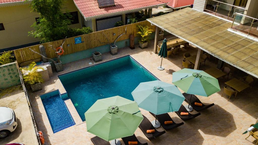 a patio area with umbrellas, chairs, and tables at Chez Bea Luxury Villa in Baie Sainte Anne
