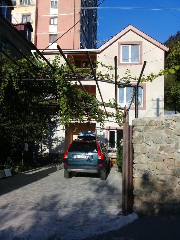 un'auto parcheggiata in un vialetto di fronte a una casa di Elmira a Borjomi