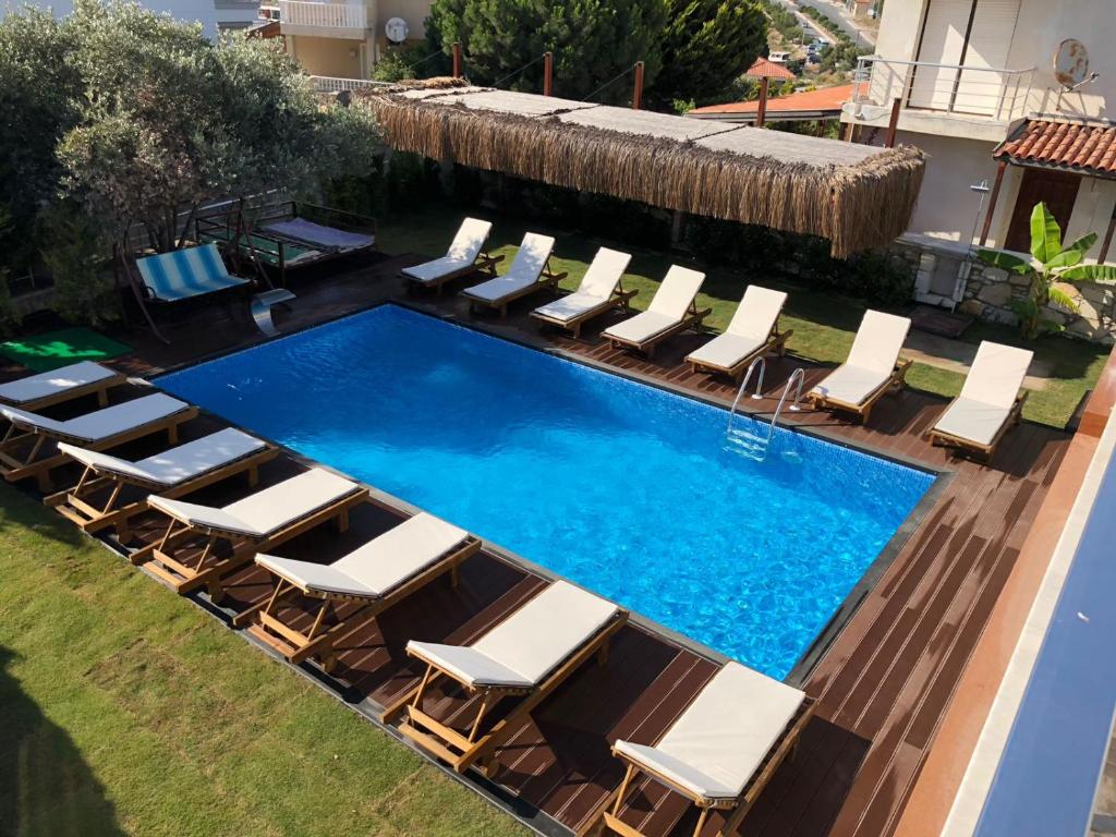 una vista aérea de una piscina con tumbonas y sillas en Cesmeli Boutique Hotel - Çeşme, İzmir en Cesme