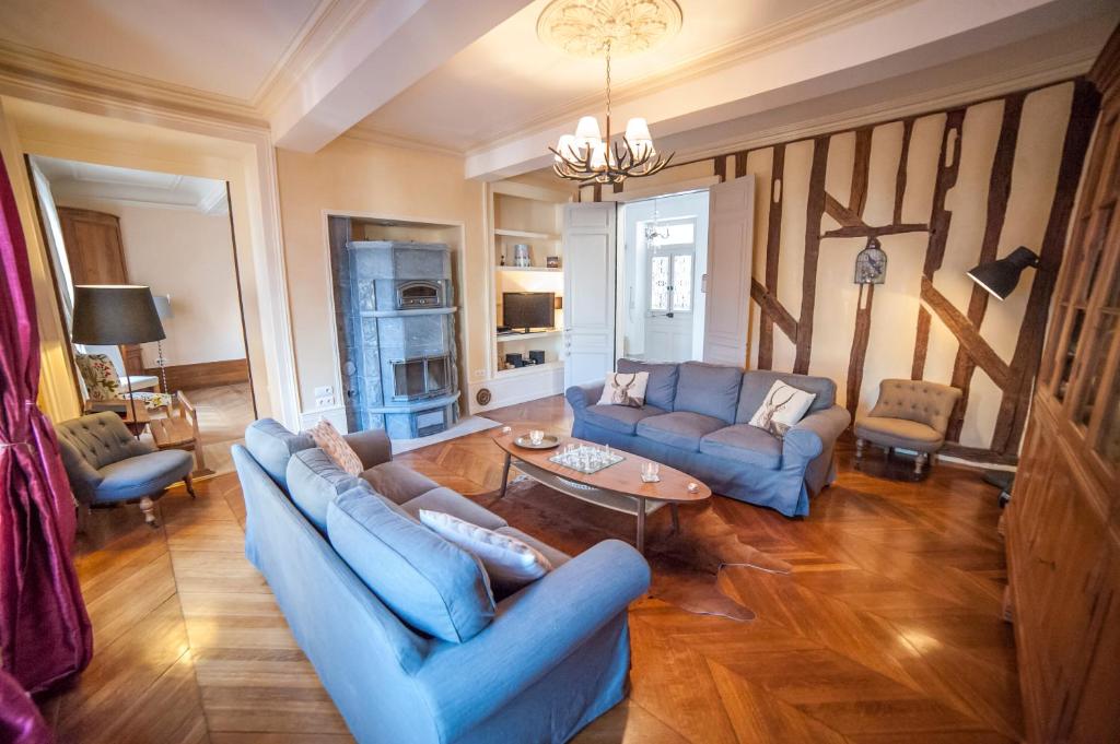 ein Wohnzimmer mit blauen Sofas und einem Tisch in der Unterkunft Maison des 7 lieux in Chablis