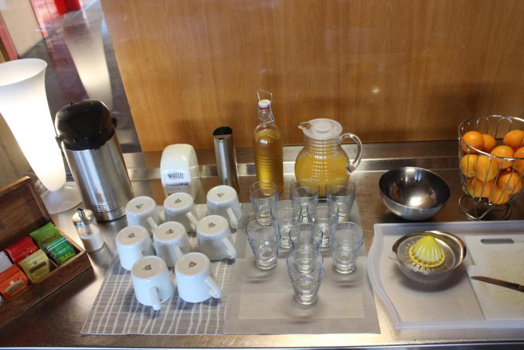 a counter with a bunch of cups and glasses on it at Hotel le Corbusier in Marseille