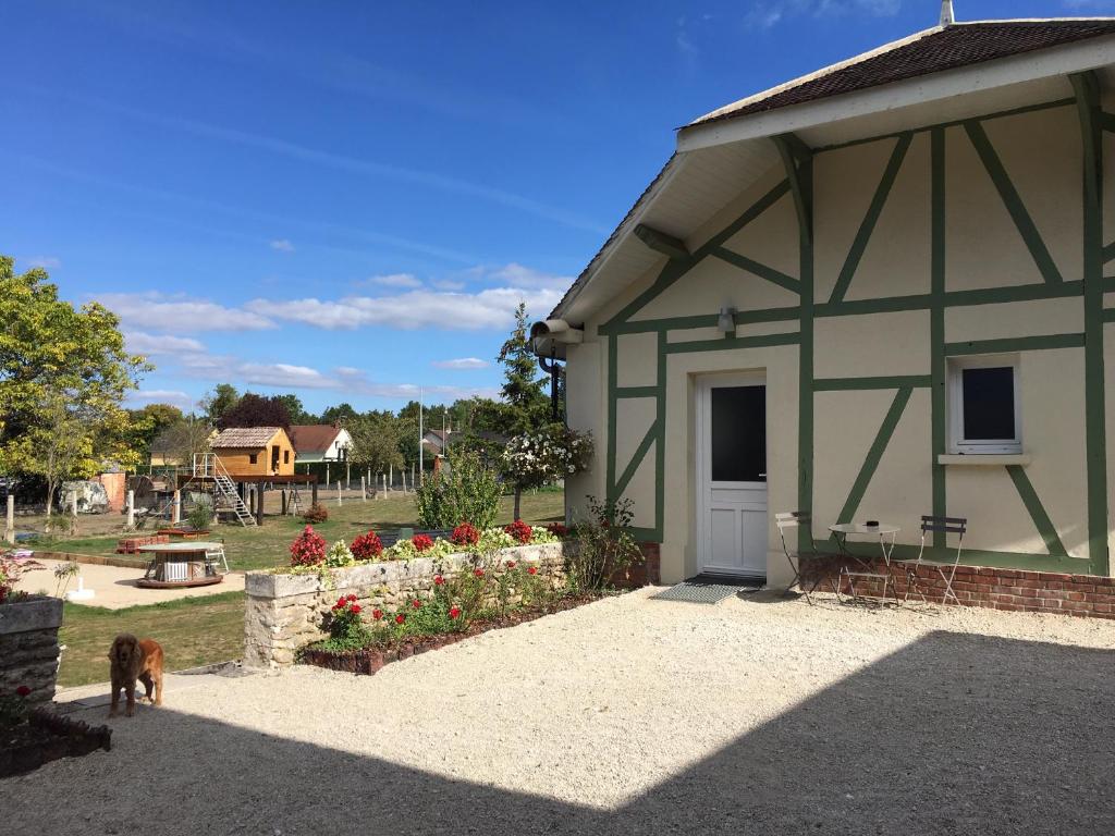 a green and white building with a dog standing outside at La maison de Louna in Saint-Parres-lès-Vaudes