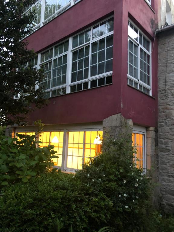 a red building with lights in the windows at Oktheway Casa da Escola in Sarria