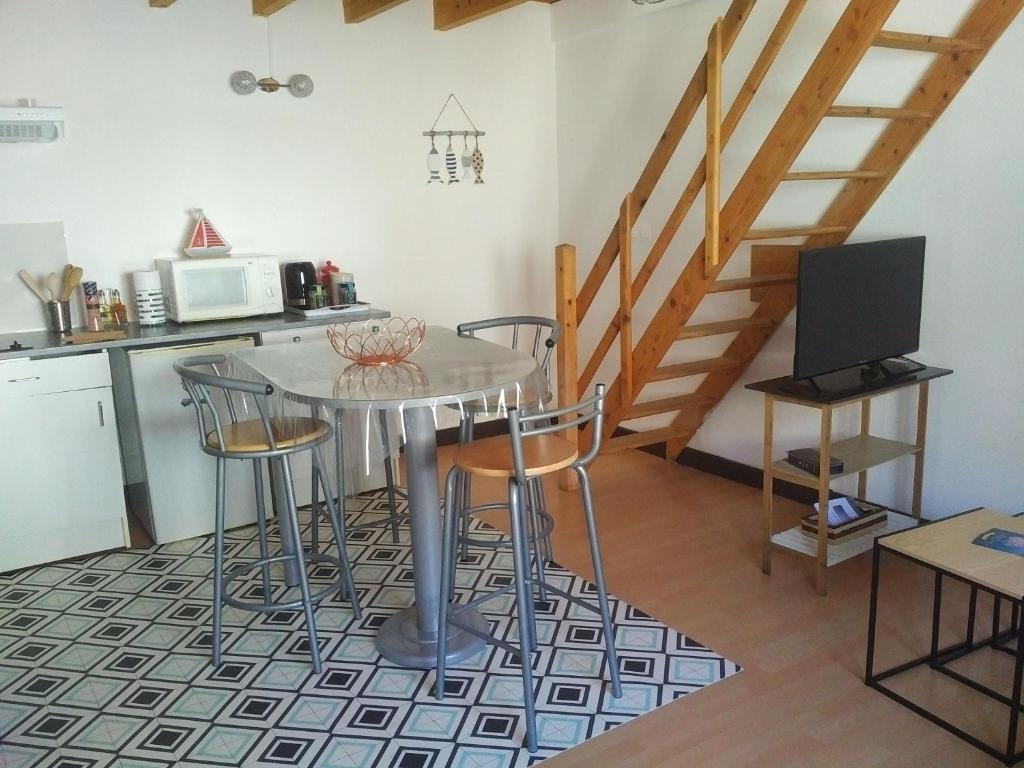 une cuisine avec une table avec des chaises et un micro-ondes dans l'établissement appartement au coeur de Chatelaillon-plage, à Châtelaillon-Plage