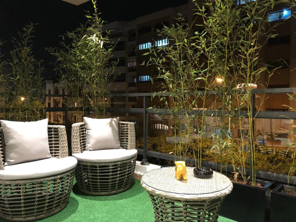 d'une terrasse avec des chaises en osier et une table. dans l'établissement City Center Apartment with Terrace, à Casablanca