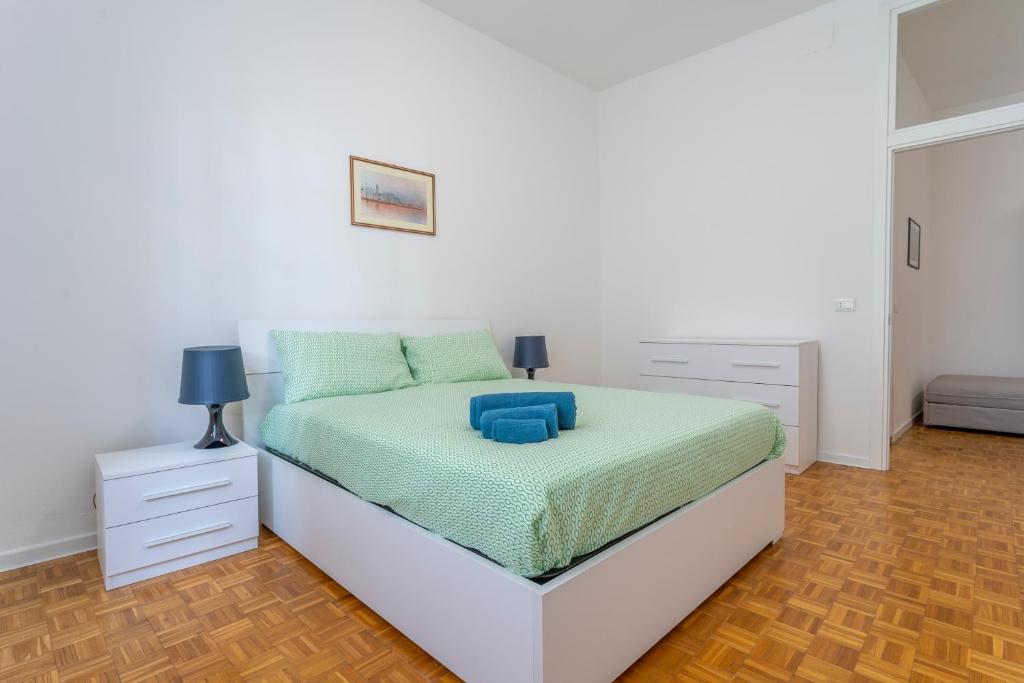 una camera bianca con letto e comodino di Ricasoli Garden Modern Apartments a Udine