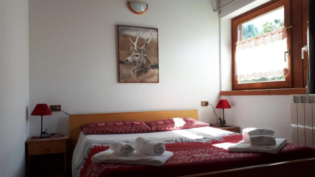 a bedroom with a bed with towels on it at Due Parchi B&B in Vezza dʼOglio