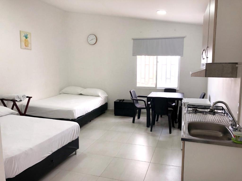 Zimmer mit 2 Betten und einer Küche mit einem Waschbecken in der Unterkunft CARIBE 102 - 1 in San Andrés