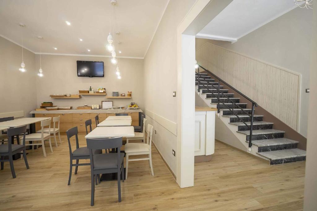 un restaurant avec des tables et des chaises et un escalier dans l'établissement Albergo Africa, à Volterra