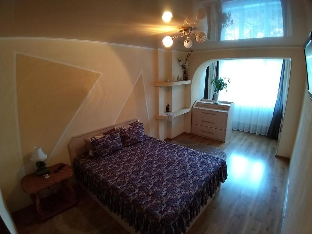 Habitación pequeña con cama y ventana en Апартаменты, en Izmaíl