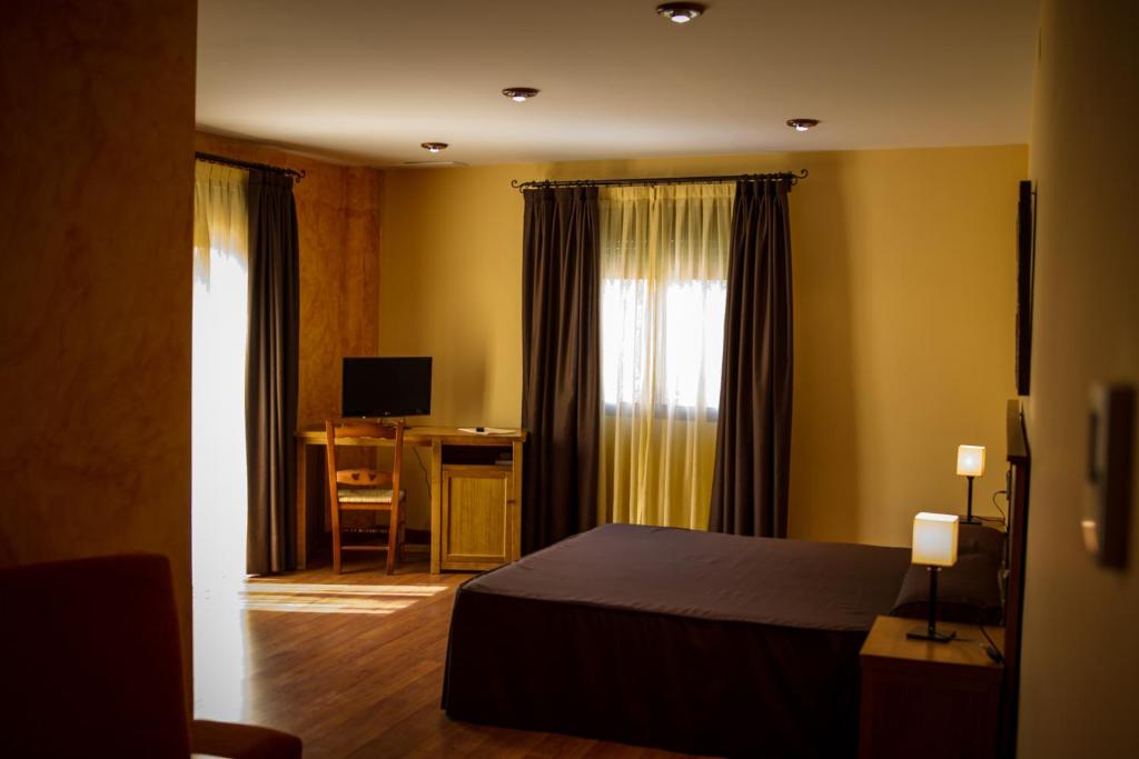 1 dormitorio con 1 cama y escritorio en una habitación en Hostal Rural el Nacimiento, en Deifontes