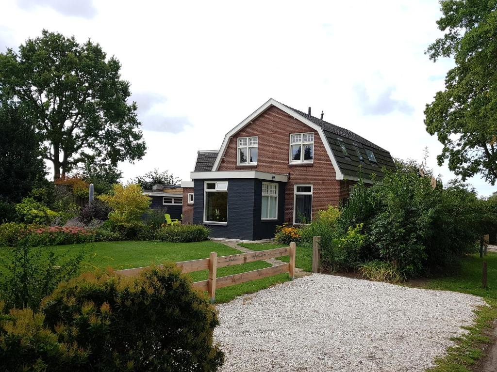 a house with a fence in front of it at Gastenverblijf Tjoene in Diepenveen