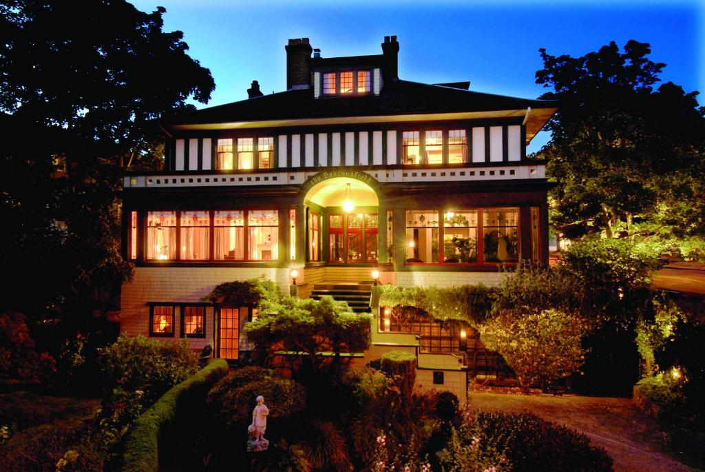 een groot huis met een vrouw die ervoor loopt bij Beaconsfield Bed and Breakfast - Victoria in Victoria