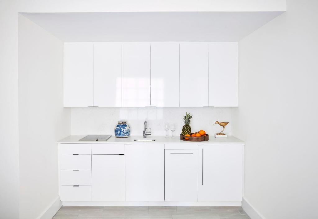 a white kitchen with white cabinets and a sink at Isla Bella Beach Resort & Spa - Florida Keys in Marathon