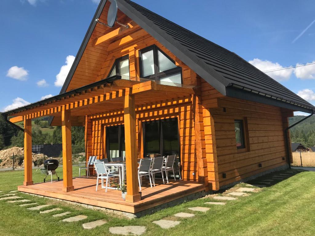 Cabaña de madera con terraza y sillas en Miętusowa Chata pod Babią, en Zawoja