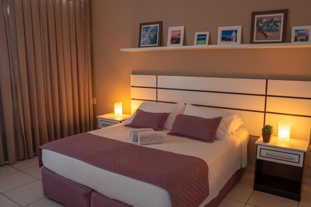 um quarto com uma cama grande com duas luzes em Hotel Marlen em Cabo Frio