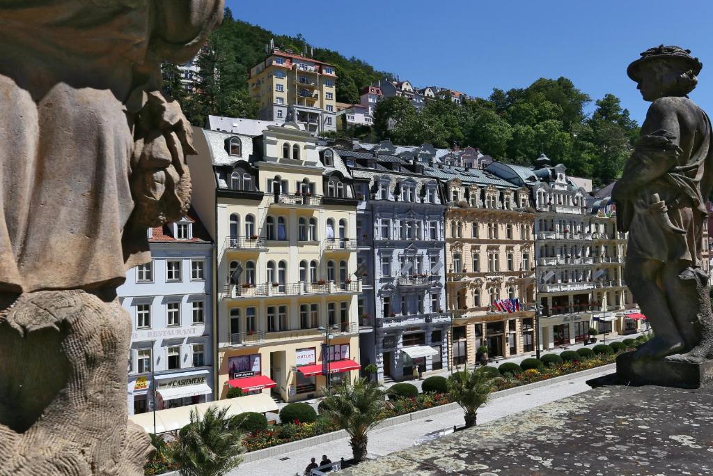 a statue in front of a city with buildings at ASTORIA Hotel & Medical Spa in Karlovy Vary