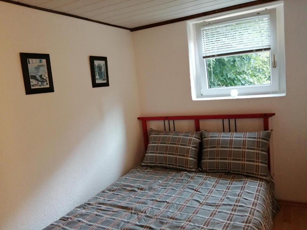 małą sypialnię z łóżkiem z oknem w obiekcie Haus Königstein FeWo Bielablick w mieście Königstein an der Elbe