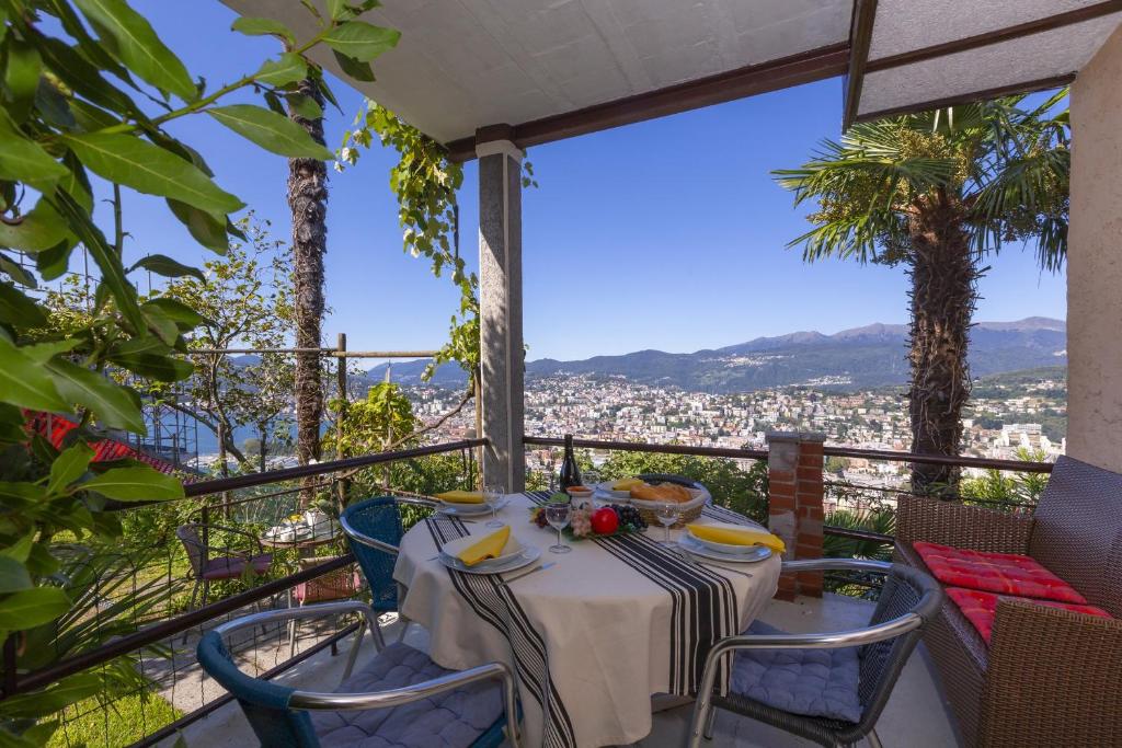 einen Tisch und Stühle auf einem Balkon mit Aussicht in der Unterkunft Bellavista Albonago in Lugano