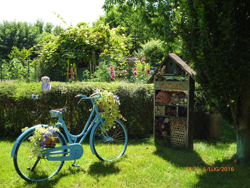 Una bicicleta azul estacionada en la hierba junto a una casa de pájaros en Bed & Bike Belfiore, en Montagnana