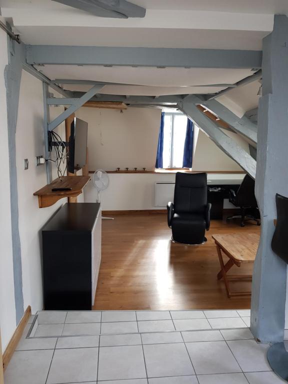 an attic room with a desk and chairs in it at Le Nid Douillet in Auxerre
