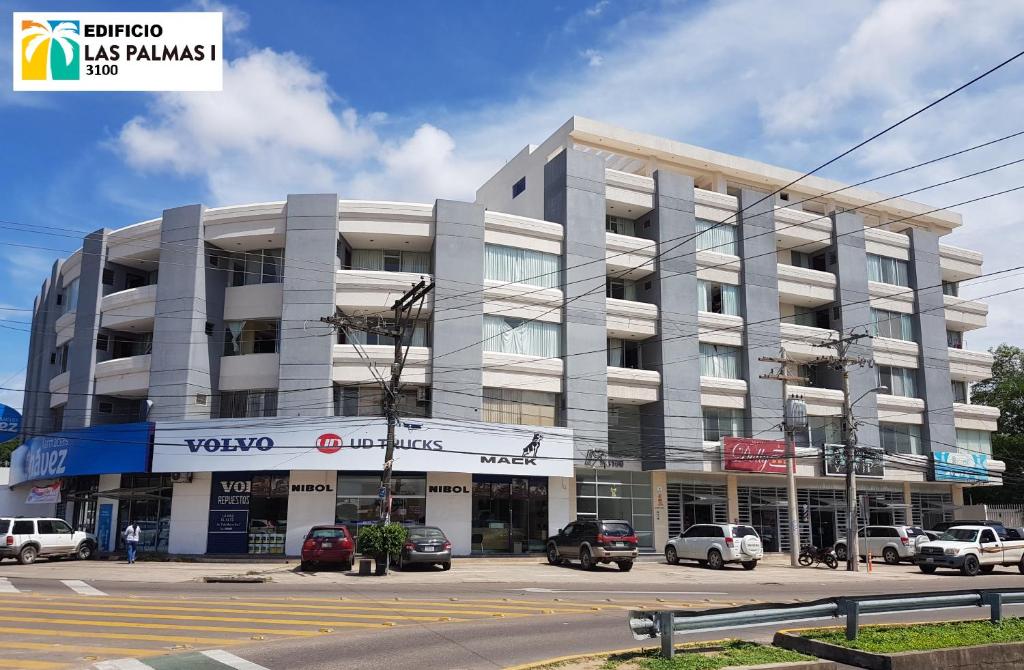 un gran edificio con coches estacionados frente a él en Edificio Las Palmas 3100 en Santa Cruz de la Sierra