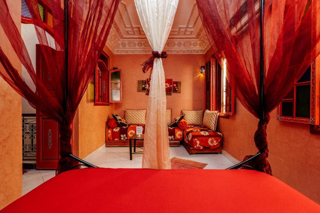 een kamer met rode gordijnen en een woonkamer bij Riad For S in Marrakesh