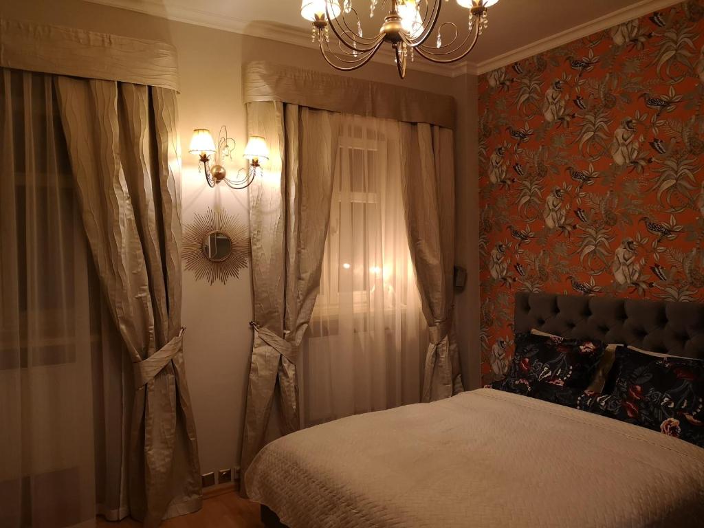 Schlafzimmer mit einem Bett und einem Kronleuchter in der Unterkunft Best Apartments Więzienna Monkeys in Breslau