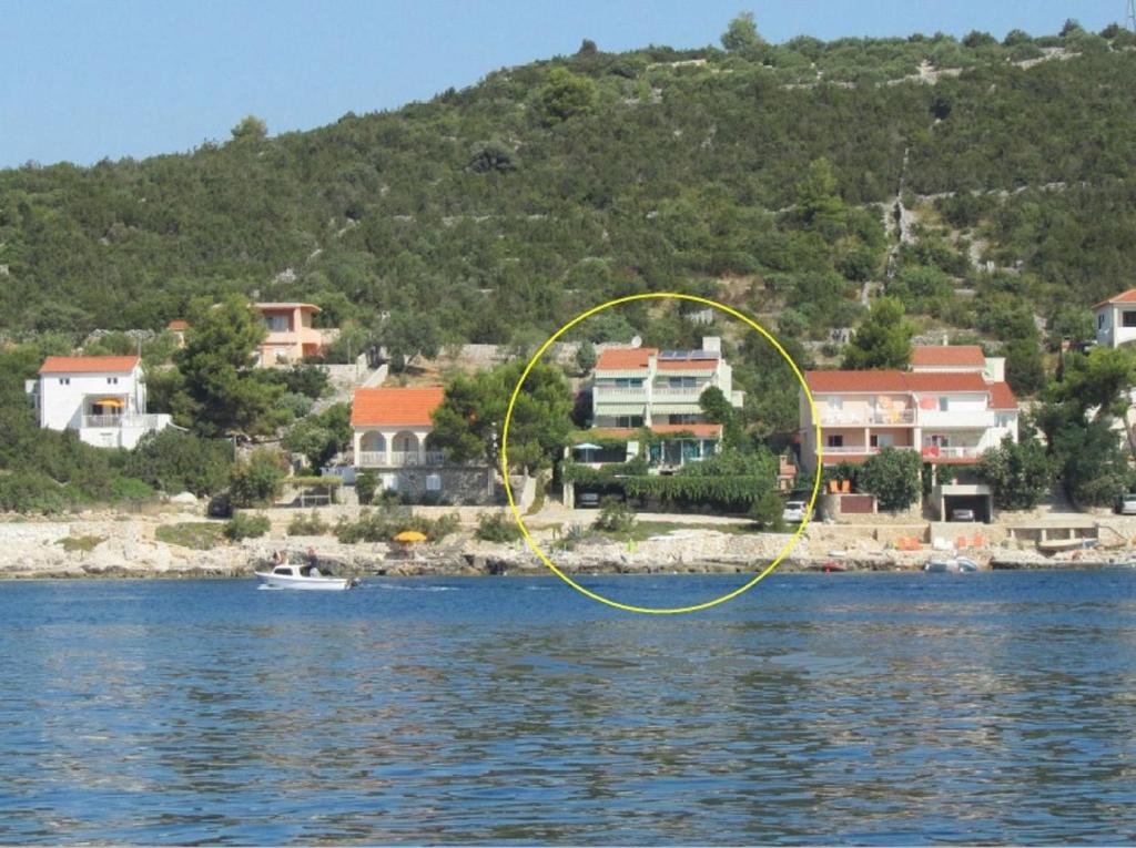 a house on the shore of a body of water at Apartments Tonka - 10m from beach in Vinišće