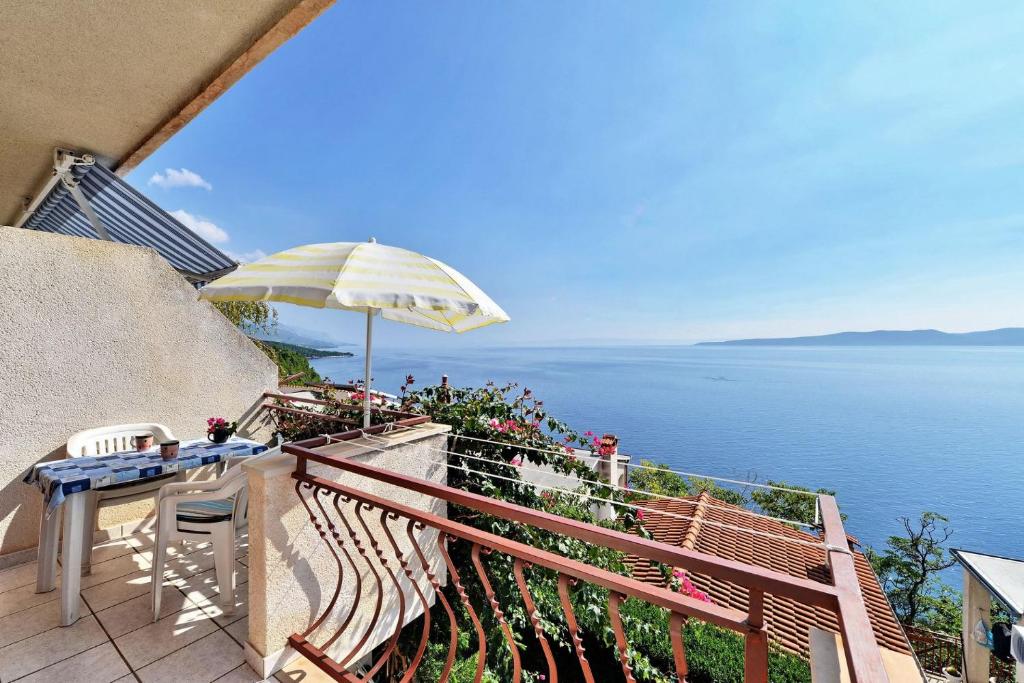 a balcony with a table and an umbrella at Apartments Goran - 150m from sea in Brela