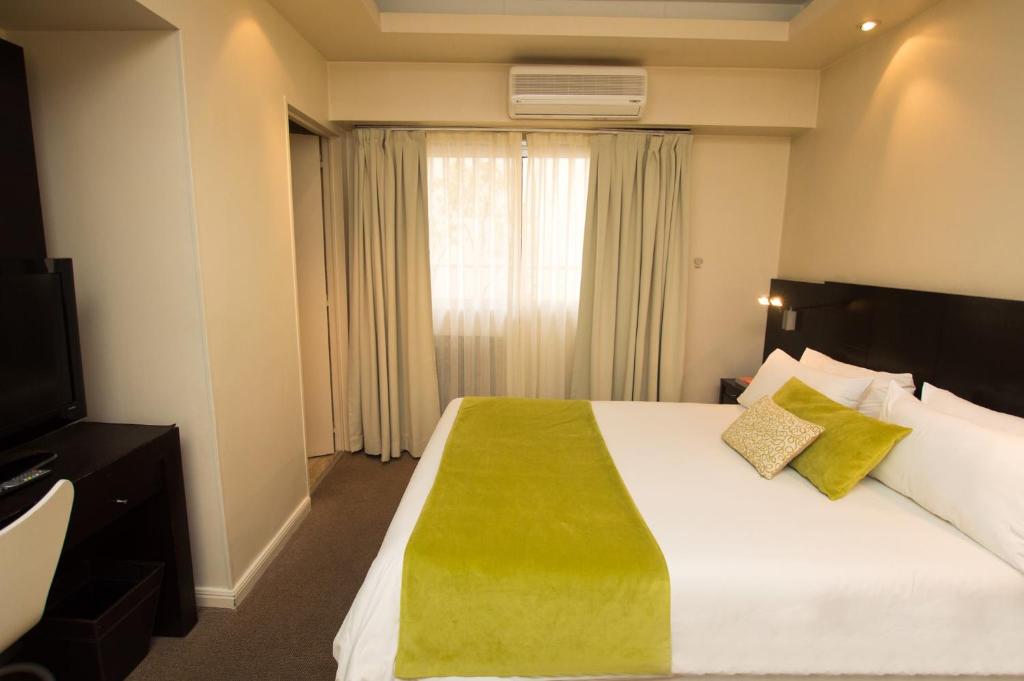 pokój hotelowy z dużym łóżkiem i oknem w obiekcie Ulises Recoleta Suites w BuenosAires