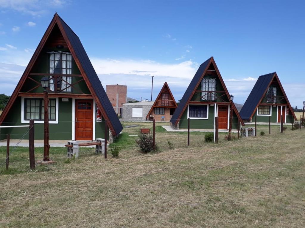 uma fila de casas rústicas num campo em La Ñata em Tornquist