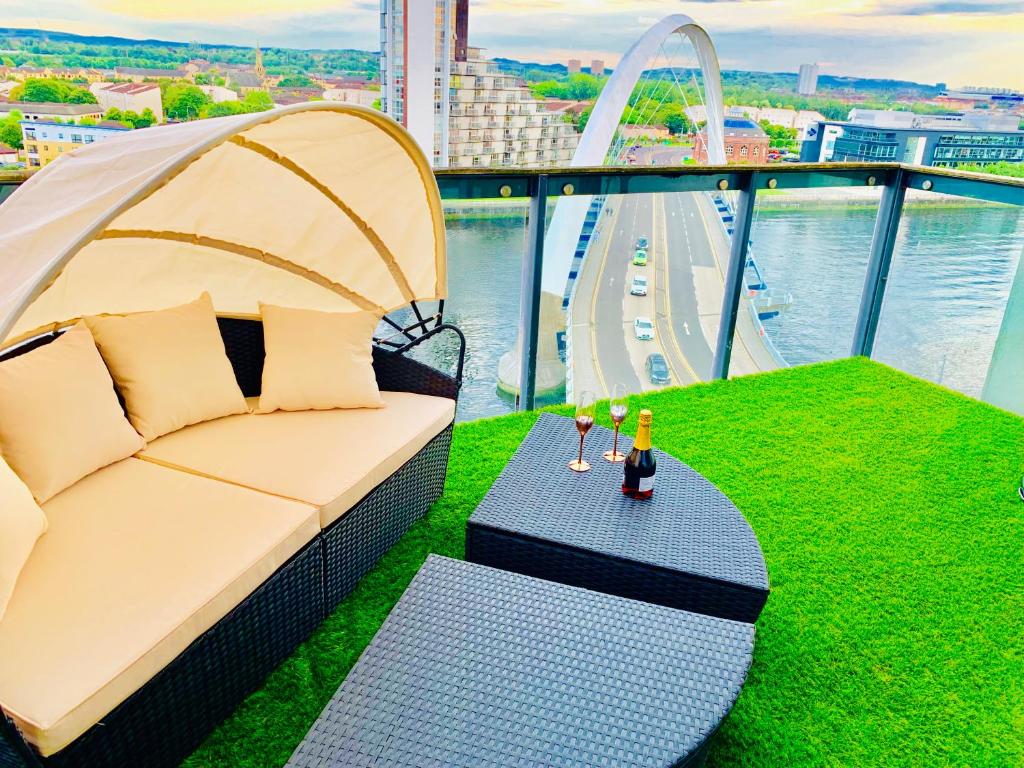 a couch and a table on top of a building at Glasgow City Centre - The PENTHOUSE with RiverViews - (Duplex, 3 Bedrooms, 3 Bathrooms, 2 Living rooms/Kitchen, Private SKY Terrace, 2 Parkings, Top Floor, Huge - 2100 sq ft, SECC HYDRO) in Glasgow