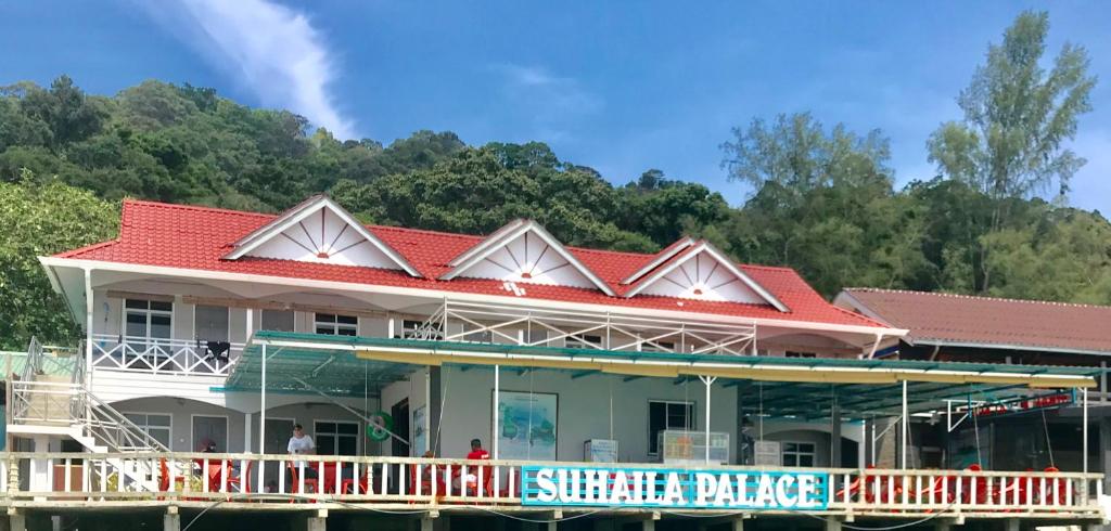 a building with a red roof on the water at Suhaila Palace in Perhentian Islands