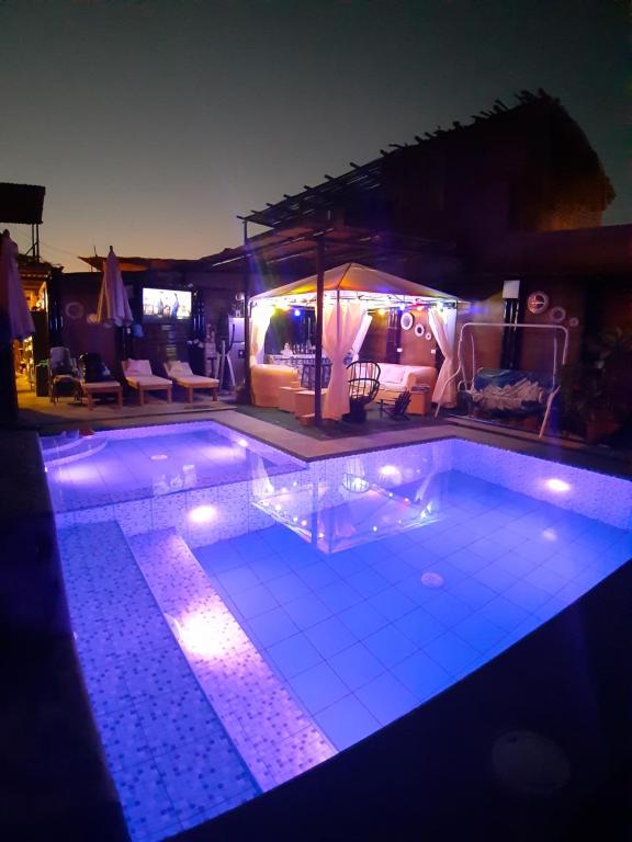 una piscina por la noche con luces encendidas en Casa Aura Del Mar, en Máncora