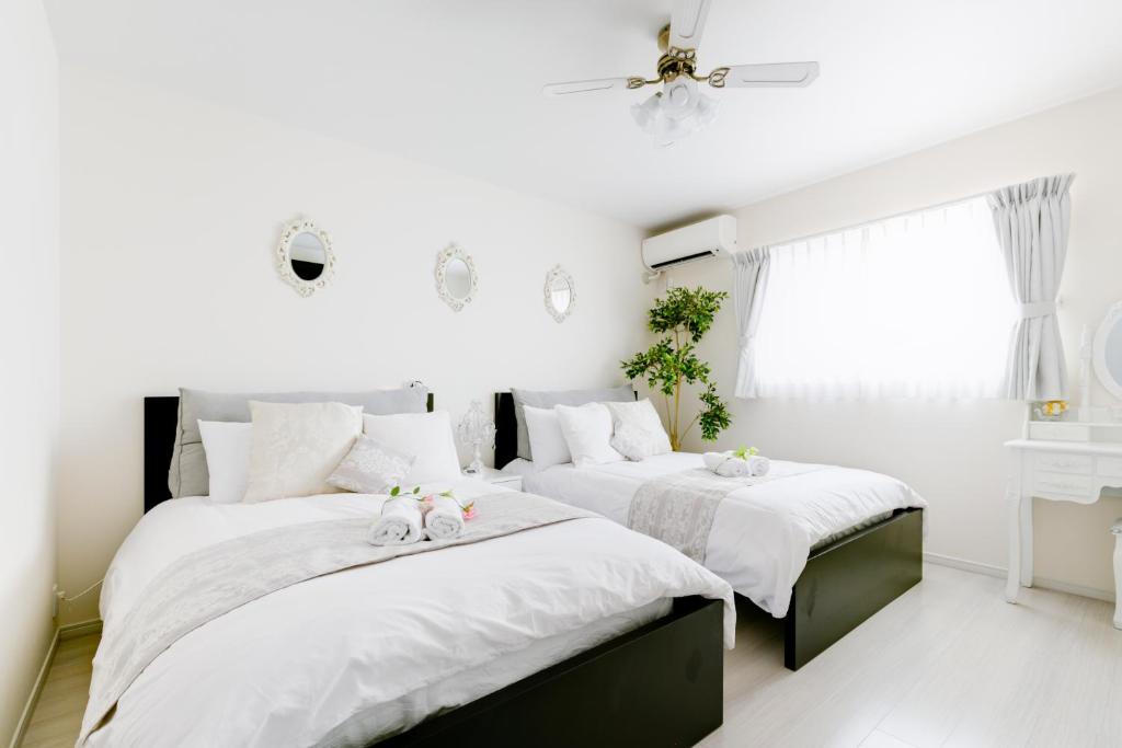 a bedroom with two beds with stuffed animals on them at Villa de Class in Osaka