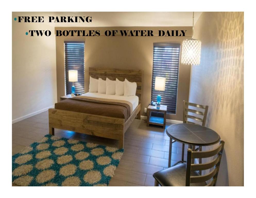 ein Schlafzimmer mit einem Bett, einem Tisch und einem Stuhl in der Unterkunft Thunderbird Boutique Hotel in Las Vegas