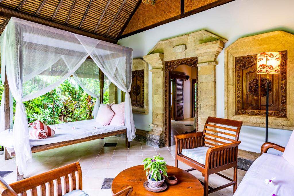 a porch with a bed and a window at Taman Selini Wahana Beach Resort in Pemuteran