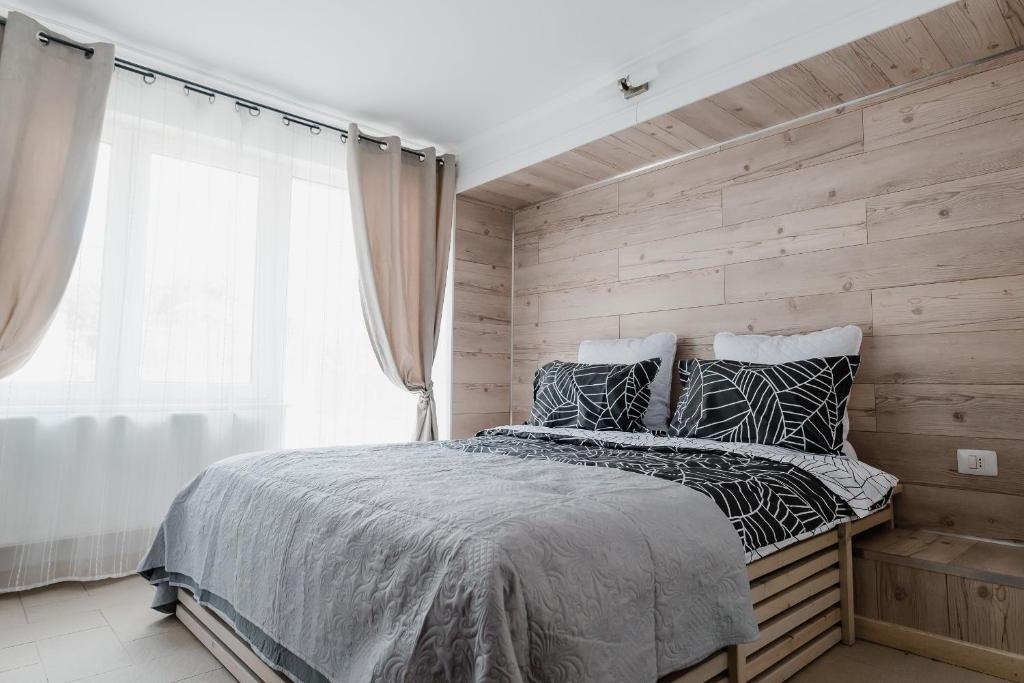 a bedroom with wooden walls and a bed with pillows at Casa Biriș in Cluj-Napoca