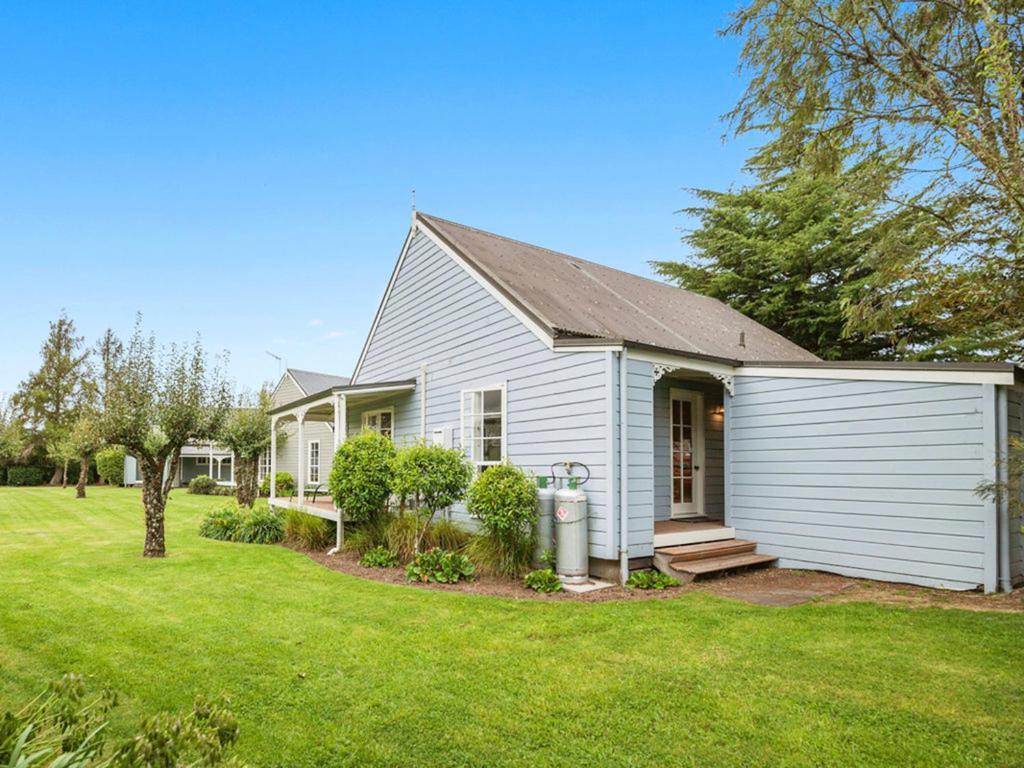 a white house with a yard at Wonderful 2BR Cottage Nr Huka Falls w Aircons in Taupo
