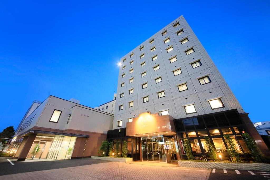 a large white building with lights on at Maple Inn Makuhari in Chiba