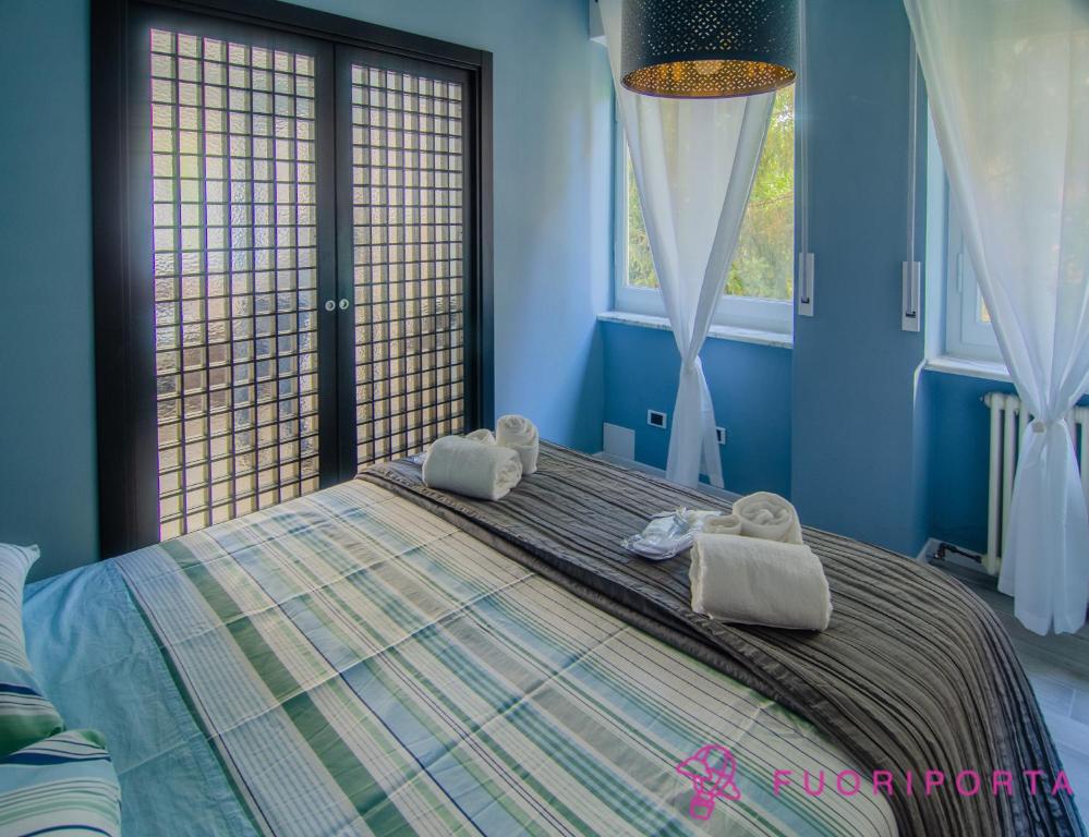 Un dormitorio azul con una cama con toallas. en Residenza Bolzoni Avio, en Parma