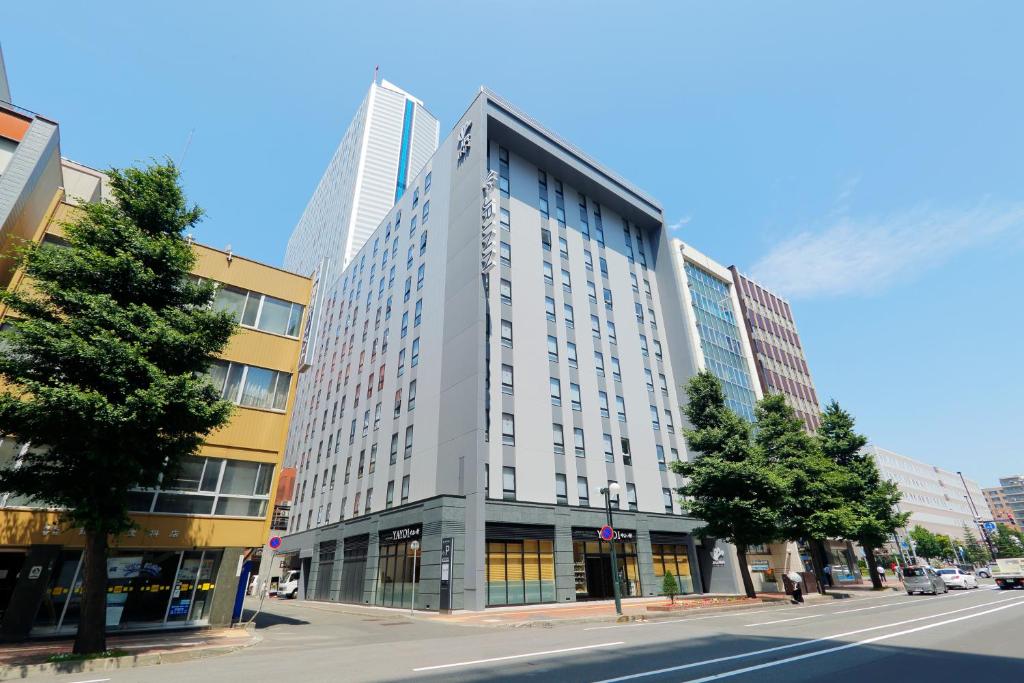 un edificio alto en una calle de la ciudad con una calle en JR Inn Sapporo-eki Minami-guchi en Sapporo