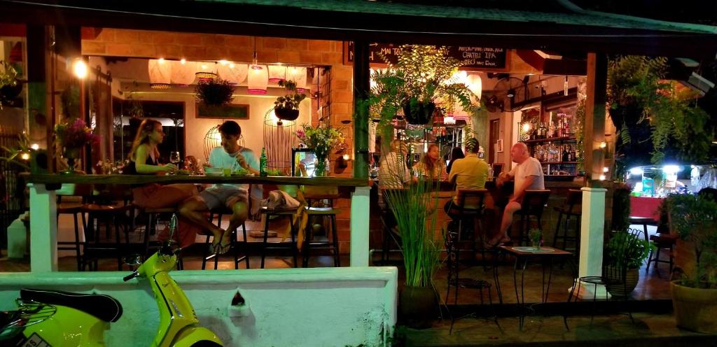 a group of people sitting at a bar at night at Soi One Boutique Bedrooms in Pai