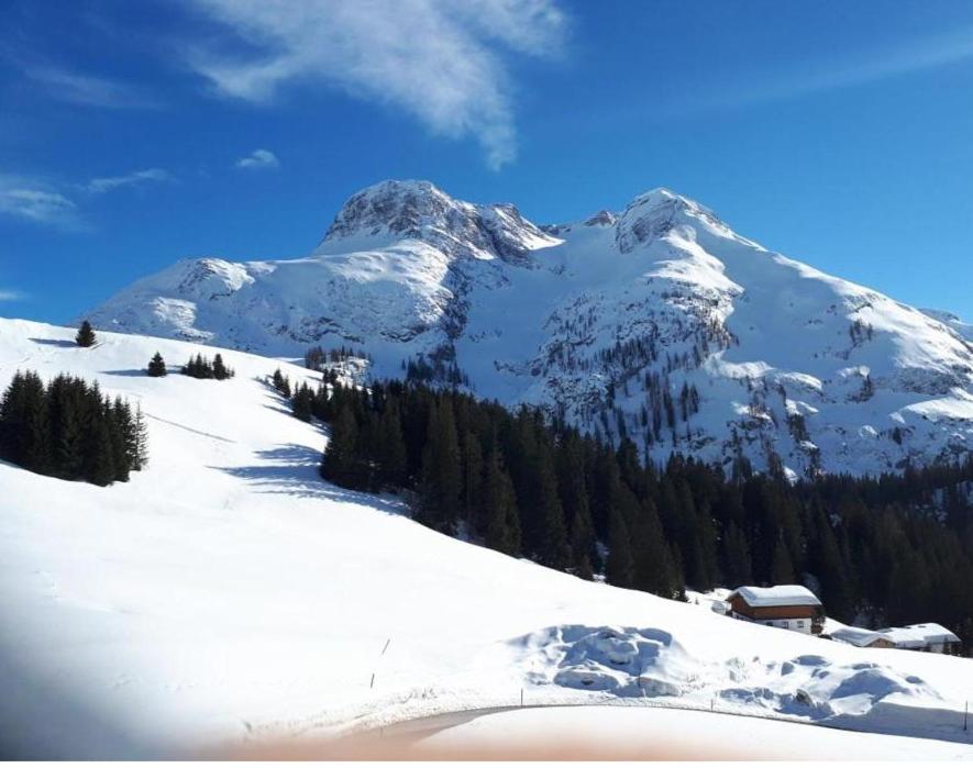 a snow covered mountain with a house in front of it at Panorama in Warth am Arlberg