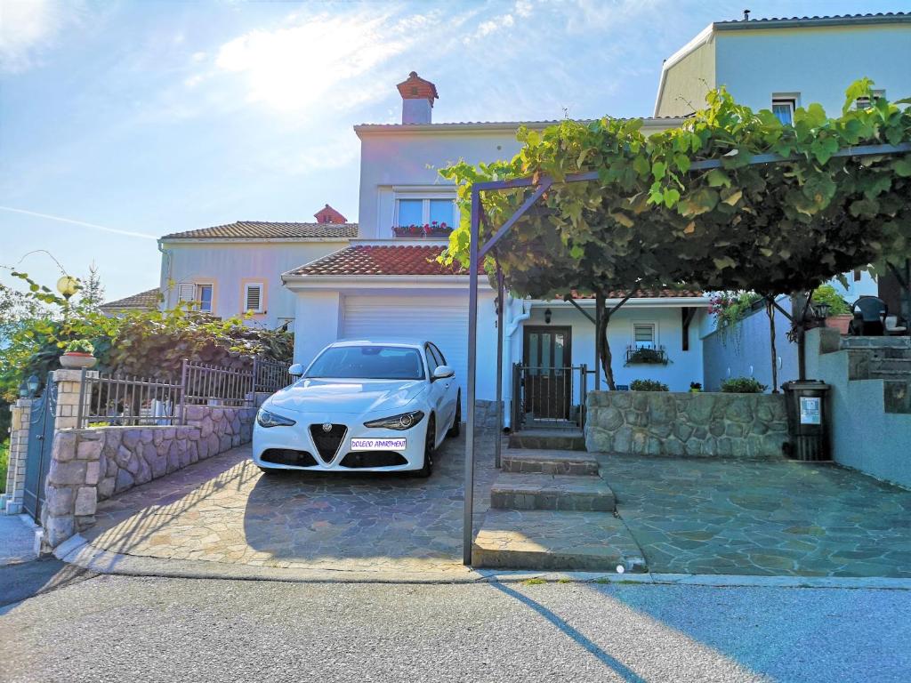 un coche blanco estacionado frente a una casa en Doleco Apartment en Opatija