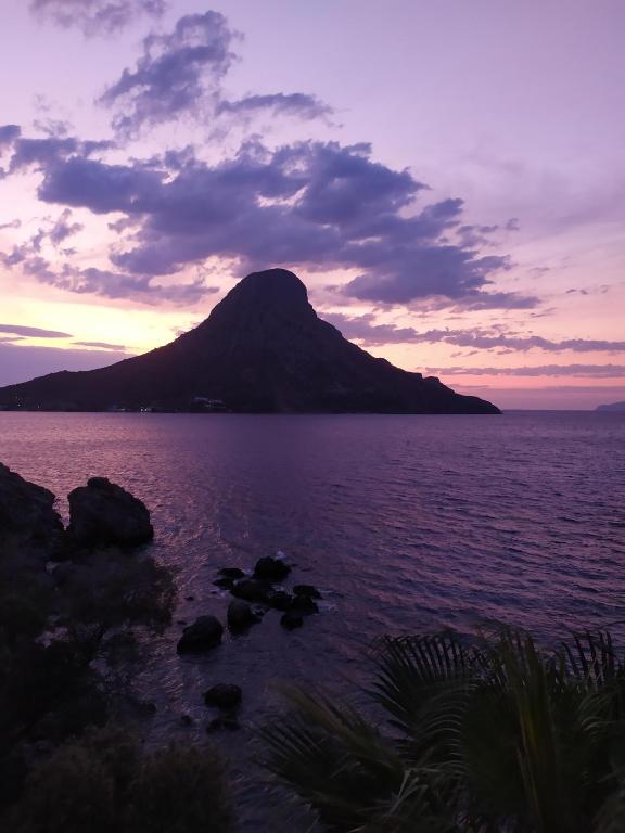 a mountain in the middle of a body of water at Fatolitis Studios in Masouri